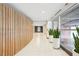 Bright hallway with wood-paneled wall, white tile floors, and decorative plants near large windows at 943 Peachtree Ne St # 902, Atlanta, GA 30309