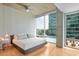 Serene bedroom featuring hardwood floors, modern ceiling fan, and large windows with city views at 943 Peachtree Ne St # 902, Atlanta, GA 30309