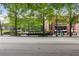 Street view of a commercial building with lush trees and a busy street with shops nearby at 943 Peachtree Ne St # 902, Atlanta, GA 30309
