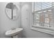 Stylish powder room featuring a modern sink, oval mirror and window with natural light at 3044 Lauren Parc Rd, Decatur, GA 30032