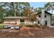 Spacious backyard features deck with patio seating, fire pit, and mature trees at 3480 Tanbark Ne Ct, Brookhaven, GA 30319