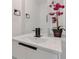 Elegant bathroom featuring a modern sink with black fixtures, a mirror, and a decorative plant at 3480 Tanbark Ne Ct, Brookhaven, GA 30319