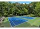 Two tennis courts surrounded by trees offer a tranquil and scenic playing experience at 3480 Tanbark Ne Ct, Brookhaven, GA 30319