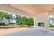 Covered outdoor patio with a brick fireplace, stone floors, and a view of the landscaped backyard at 3118 Lanier Ne Dr, Brookhaven, GA 30319