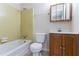 Bathroom featuring tile surround tub, vanity sink with mirror, and toilet at 6708 Bedford Rd, Rex, GA 30273