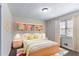 Cozy bedroom with built-in shelving, a comfortable bed, and bright, natural light from the window at 6708 Bedford Rd, Rex, GA 30273