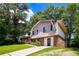 Two-story home with brick accents, an attached garage, and a driveway, surrounded by lush trees at 6708 Bedford Rd, Rex, GA 30273