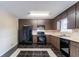 Functional kitchen with dark cabinetry, updated appliances, and a tiled floor, ready for cooking at 6708 Bedford Rd, Rex, GA 30273