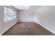 Empty room with plush carpeting, neutral walls, and a bright window offering ample natural light at 6708 Bedford Rd, Rex, GA 30273