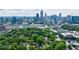 An aerial view of a neighborhood with a dense tree canopy set against the backdrop of the Atlanta skyline at 1190 Francis Nw St, Atlanta, GA 30318