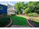 Landscaped backyard with lush green lawn and brick-lined pathway leading to a modern home at 1190 Francis Nw St, Atlanta, GA 30318