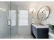 Elegant bathroom featuring a walk-in shower, wainscoting, and a stylish vanity with a round mirror at 1190 Francis Nw St, Atlanta, GA 30318