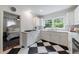 Bright kitchen features white cabinets, quartz counters, stainless steel appliances, and bold black and white flooring at 1190 Francis Nw St, Atlanta, GA 30318