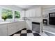 Bright kitchen features white cabinets, quartz counters, stainless steel appliances, and bold black and white flooring at 1190 Francis Nw St, Atlanta, GA 30318