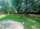 The well manicured backyard features mature trees and a concrete patio at 148 Parkside Dr, Stockbridge, GA 30281