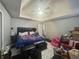 The main bedroom has a tray ceiling, ceiling fan and a door to the main bathroom at 148 Parkside Dr, Stockbridge, GA 30281