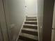 View of stairway leading to second level of the house; gray walls and carpet flooring at 148 Parkside Dr, Stockbridge, GA 30281