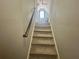 View of stairway leading to attic with gray walls, carpet flooring, and wood handrail at 148 Parkside Dr, Stockbridge, GA 30281