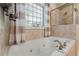 Elegant bathroom showcasing a soaking tub with tile surround and a glass block window at 200 Mystic Ct, Atlanta, GA 30342