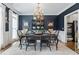 Formal dining room showcasing stylish lighting, dark-toned walls, and access to the kitchen at 200 Mystic Ct, Atlanta, GA 30342