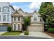Charming brick home featuring a two-car garage, manicured lawn, and beautiful landscaping at 200 Mystic Ct, Atlanta, GA 30342