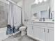 Bright bathroom with white vanity, neutral tiling, tub with shower, and decorative accents at 449 Carmichael Cir, Canton, GA 30115