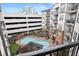 Aerial view of the community pool featuring lounge seating, a pergola, and a parking garage at 901 Abernathy Ne Rd # 5140, Sandy Springs, GA 30328