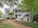 Exterior of a two-story home with stairs leading to the entrance with natural light and landscaping at 108 Countryside Se Pl, Smyrna, GA 30080