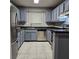 Kitchen with stainless steel appliances, gray cabinets, granite countertops, and tile floors at 108 Countryside Se Pl, Smyrna, GA 30080