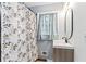 Bathroom with a modern vanity, tile walls, neutral shower curtain and an oval mirror at 1326 Stella Sw Cir, Mableton, GA 30126