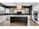 Modern kitchen featuring stainless steel appliances, black backsplash, white cabinets, and marble island at 2220 Meadowvale Ne Dr, Atlanta, GA 30345