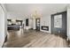 Open-concept living room with fireplace, modern light fixture, hardwood floors, and view into kitchen at 2220 Meadowvale Ne Dr, Atlanta, GA 30345