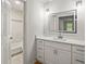 Bright bathroom features a sleek vanity with a framed mirror and a glimpse into the tiled shower at 3013 Huntshire, Doraville, GA 30340