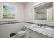 Charming bathroom with marble countertop, vanity and white subway tiles with horizontal blue border near window at 3013 Huntshire, Doraville, GA 30340