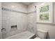 Bathroom showcasing white marble tile throughout the shower and adjacent to the toilet by the window at 3013 Huntshire, Doraville, GA 30340
