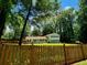 Quaint home nestled among mature trees, complemented by a charming wooden fence, creating a warm and inviting atmosphere at 4798 Mary Dale Ct, Lilburn, GA 30047