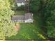 Aerial view of a charming two-story home with black shutters, nestled amongst mature trees on a spacious lot at 4798 Marydale Sw Ct, Lilburn, GA 30047