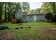 Exterior view of backyard featuring a grassy area and a wooden deck attached to the home at 4798 Marydale Sw Ct, Lilburn, GA 30047