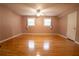 Large bedroom showcasing hardwood floors, neutral walls, and natural light from two windows at 4798 Marydale Sw Ct, Lilburn, GA 30047