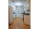 Well-lit kitchen with wooden floors and white cabinets offering ample storage space at 4798 Marydale Sw Ct, Lilburn, GA 30047