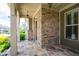 Covered front porch with stone pillars, flagstone flooring, and charming outdoor lighting at 238 Avery Ne St, Marietta, GA 30060