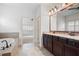 Spacious bath with double vanity and large soaking tub with neutral tile and dark wood at 238 Avery Ne St, Marietta, GA 30060