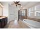 Bathroom with dark vanity, large tub, glass shower, and bright, natural light from shuttered window at 238 Avery Ne St, Marietta, GA 30060
