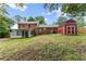 Large backyard with a barn and brick house with an enclosed sunroom, perfect for outdoor activities at 2711 Bethesda Ne Ct, Lawrenceville, GA 30044