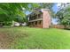 Side view of a two-story brick home with a balcony and a large, grassy lawn at 2711 Bethesda Ne Ct, Lawrenceville, GA 30044