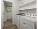 The laundry room includes storage shelves and side-by-side washer and dryer at 2711 Bethesda Ne Ct, Lawrenceville, GA 30044