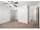 Carpeted bedroom featuring a ceiling fan, walk-in closet, and a door to the ensuite bathroom at 3440 Oaktree Way, Stonecrest, GA 30038
