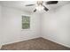 Cozy bedroom with neutral walls and carpet, featuring a ceiling fan and natural light from the window at 3440 Oaktree Way, Stonecrest, GA 30038