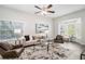 Bright and airy living room with large windows, neutral decor, ceiling fan, and stylish furnishings at 3440 Oaktree Way, Stonecrest, GA 30038