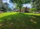An expansive backyard showcases lush grass, mature trees, and a two-story house in the background at 2206 Rhett Ct, Lawrenceville, GA 30044